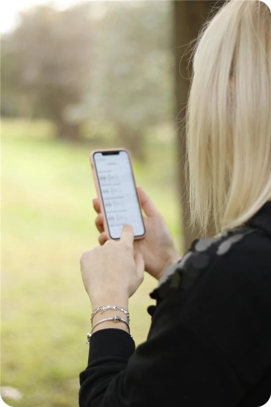  blonde girl looking at the phone with TheCoach-Link app on it.