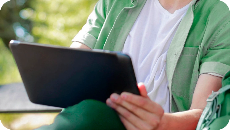 A person holding a black tablet.